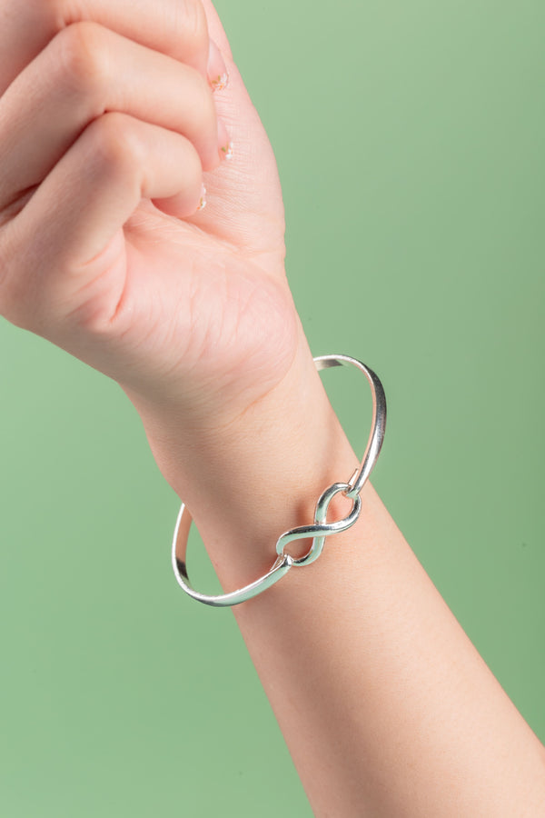 Close-up of the Infinity Cuff, showcasing a polished 4mm sterling silver band with a timeless, minimalist design