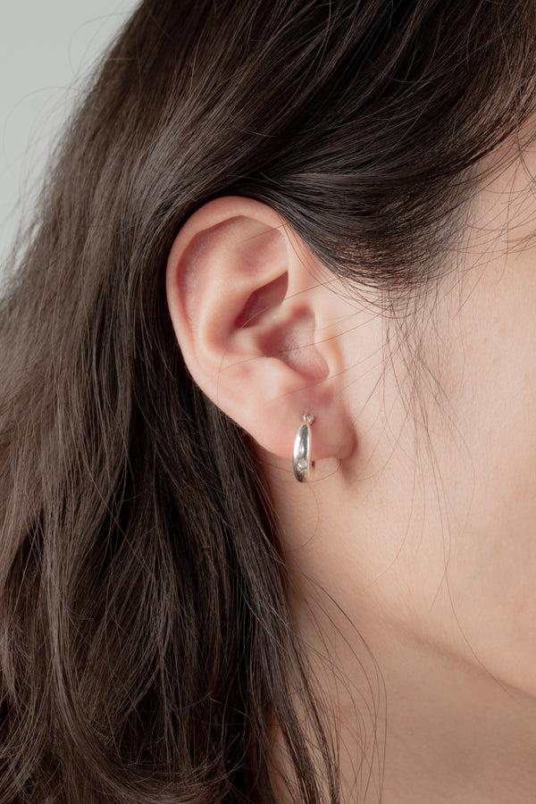 Close-up of the Minimal Loop Earrings, featuring a polished 20mm silver loop design for a timeless look