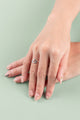 Sleek silver triangle ring on green background flatlay