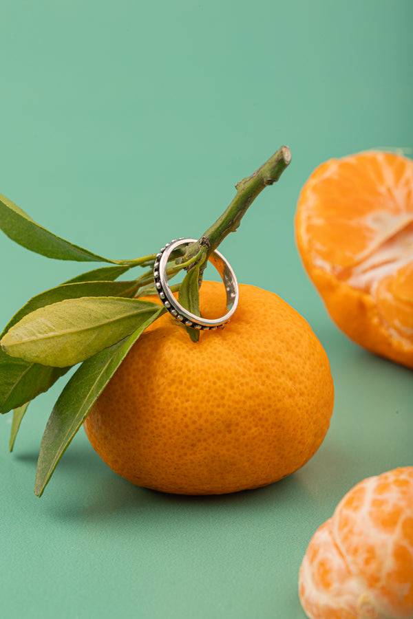 Minimalist silver band with beads, capturing nature’s zest.